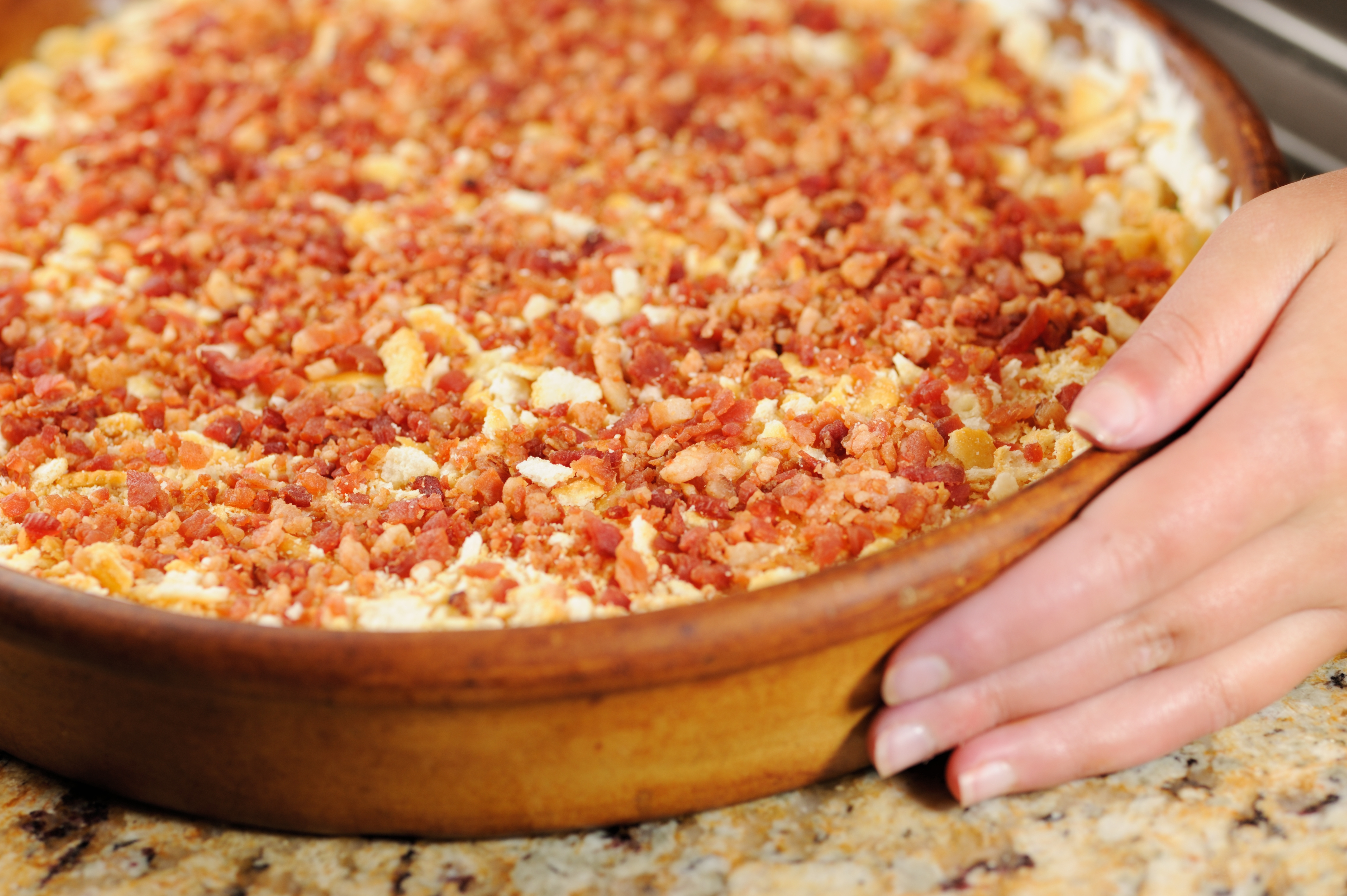 Charleston Cheese Dip is covered with cheese and bacon, and is the perfect dish for your tailgate.