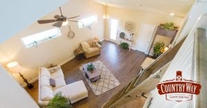 A living room with wood flooring, high ceilings, and a ladder that leads to the second story. CountryWay is a community of luxury homes.